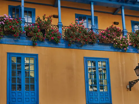 Fachada tradicional con balcones azules y flores en la Plaza del Fontán de Oviedo, uno de los rincones más emblemáticos.