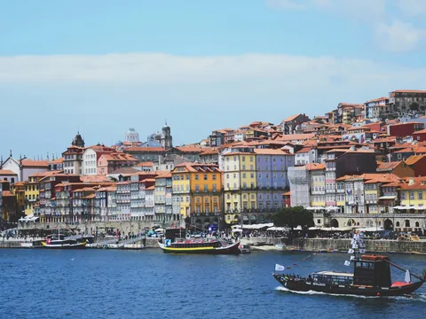 Barco rabelo navegando por el río Duero con la Ribeira de Oporto al fondo.