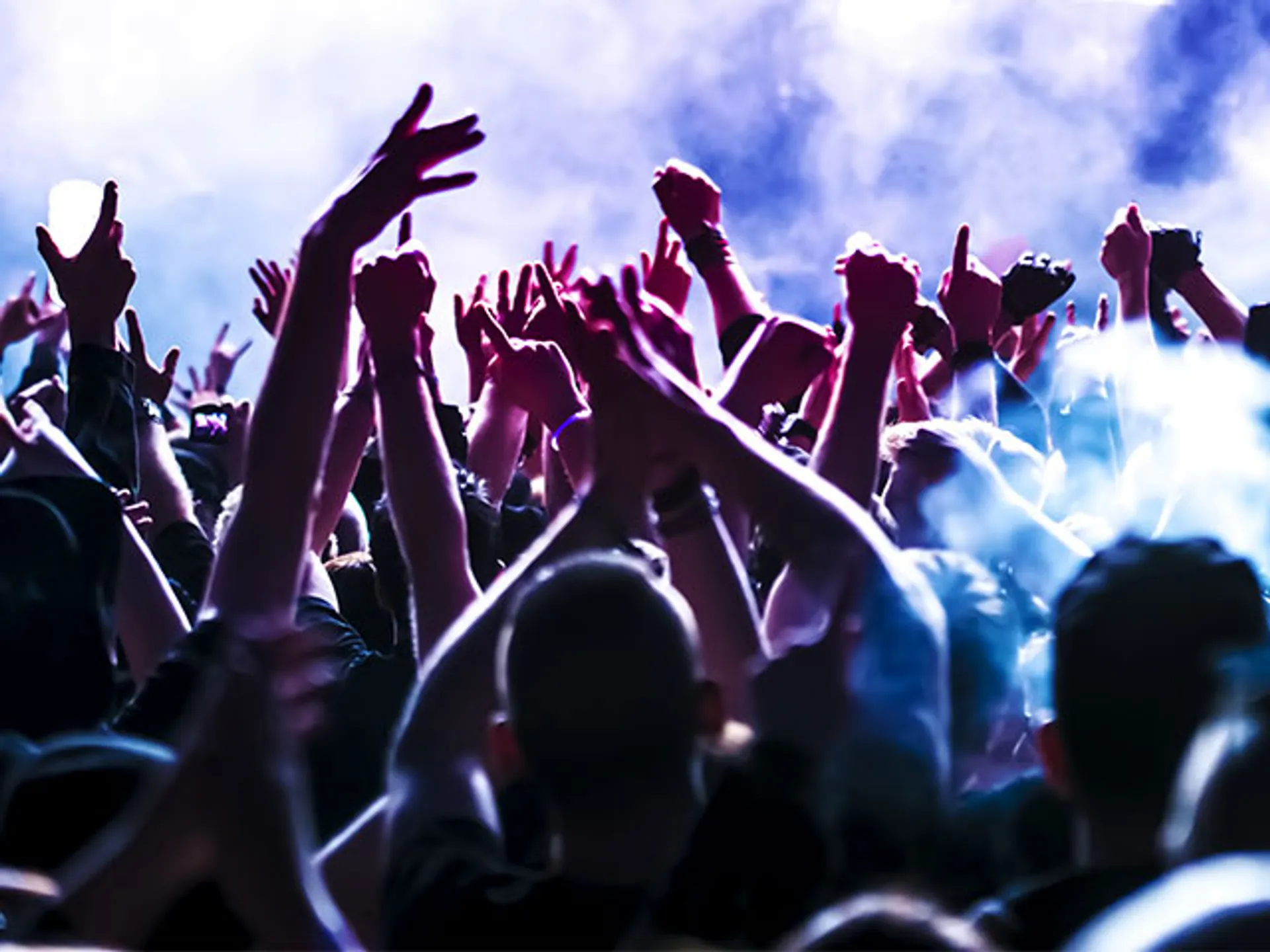 Gente con las manos en el aire de noche de fiesta