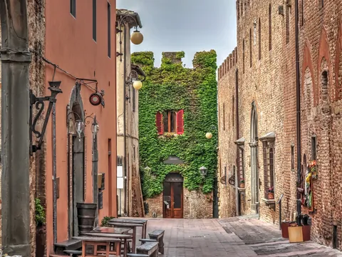 Calle medieval con casas de piedra y hiedra en la Toscana, Italia