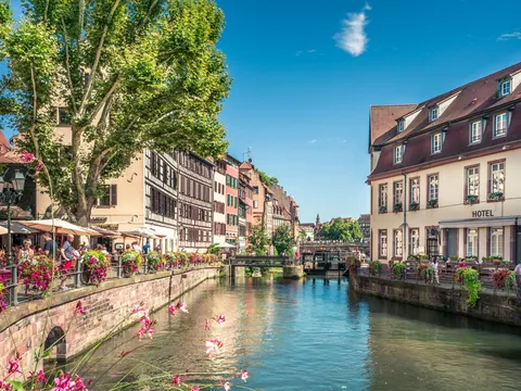 Río Ill con terrazas de cafés y flores, Estrasburgo, Francia