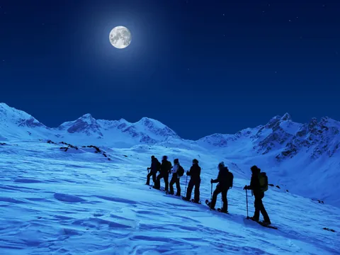 Ruta nocturna en raquetas de nieve a la luz de la luna en Fuentes de Invierno
