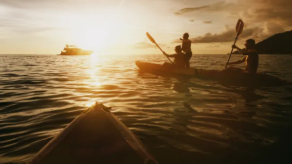Grupo en kayak y barco en el mar durante un atardecer en Es Grau, Menorca