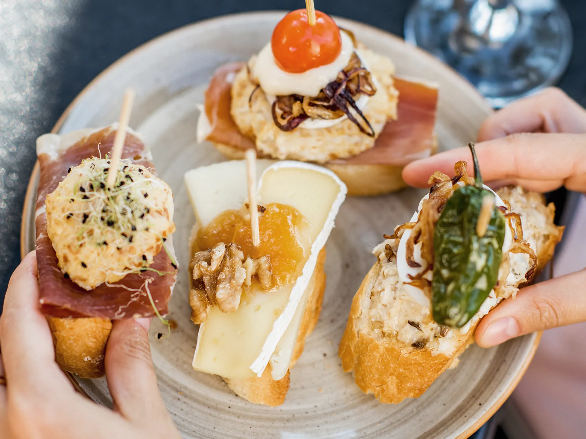 Variedad de pinchos gourmet sobre pan artesano en una terraza de San Sebastián