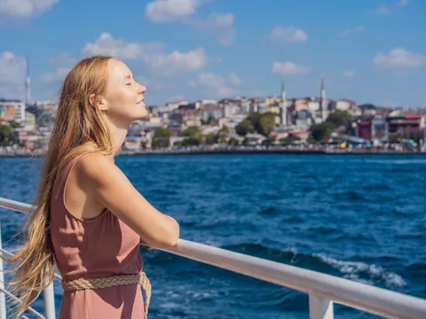 Mujer disfrutando del sol en barco por el Bósforo, Estambul, Turquía