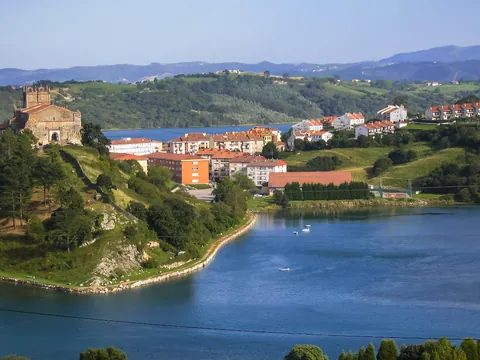Vista de San Vicente de la Barquera con la iglesia de Santa María de los Ángeles en lo alto, junto a la ría.