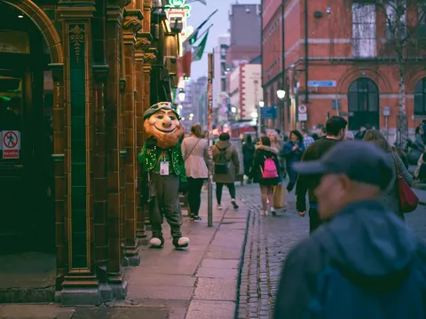 Personaje disfrazado de duende irlandés en la entrada de un pub, Dublín, Irlanda