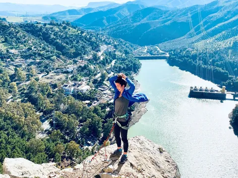Mujer con arnés en la cima de El Chorro con vistas al embalse