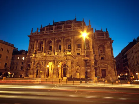 La iluminada Ópera Estatal de Hungría en Budapest de noche, con estelas de luz.