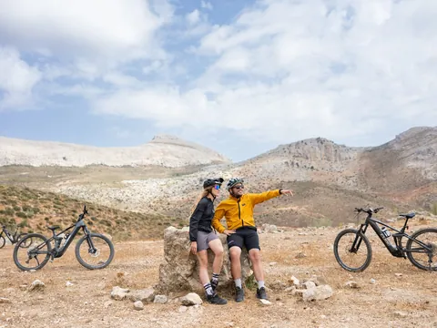 Pareja de ciclistas con e-bikes descansando en un mirador de El Chorro, Málaga