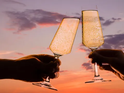 Generar alts dijo:  Brindis con copas de cava al atardecer en la costa de Valencia