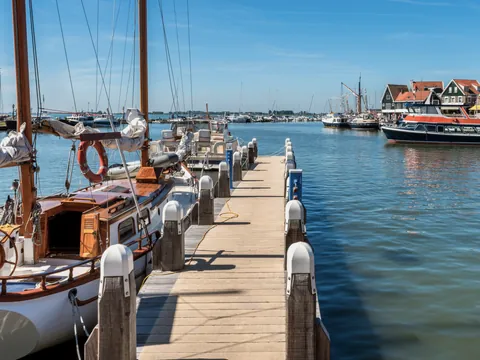 Embarcaciones atracadas en el puerto de Volendam en un día soleado.
