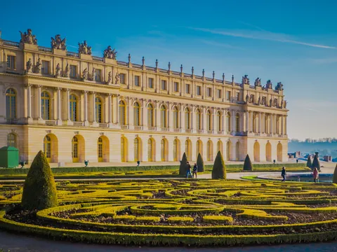 Palacio de Versalles, un gran edificio con numerosas ventanas en su fachada exterior.