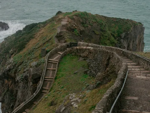 Camino de piedra hacia el mirador de San Juan de Gaztelugatxe junto al mar.