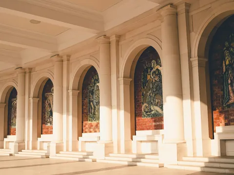 Galería porticada del Santuario de Fátima, Portugal, con mosaicos religiosos.