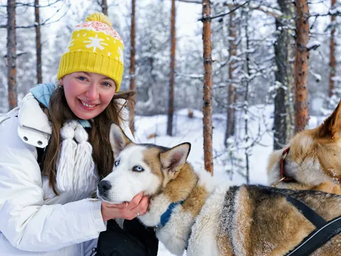 Una joven acaricia a los huskies antes de iniciar su paseo por el paraíso invernal.