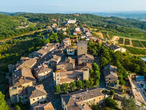 Vista aérea de pueblo medieval entre colinas de la Toscana, Italia