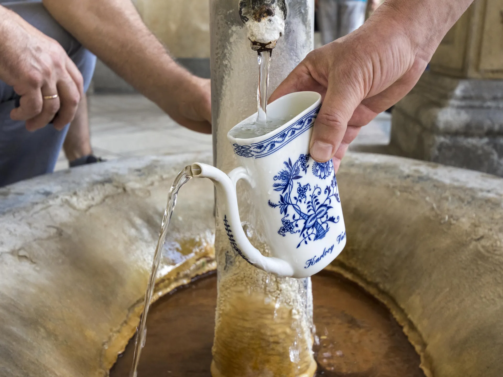 taza de pocelana llenándose en fuente de Karlovy Vary