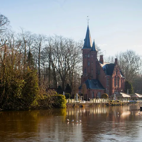 Vista del Lago del Amor en Brujas, Bélgica, con su icónico edificio rojo reflejado en el agua