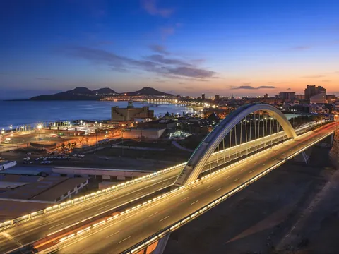 Puente de El Rincón iluminado al anochecer frente a la costa de Las Palmas.