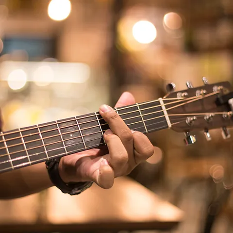 Hombre tocando guitarra acústica en un bar