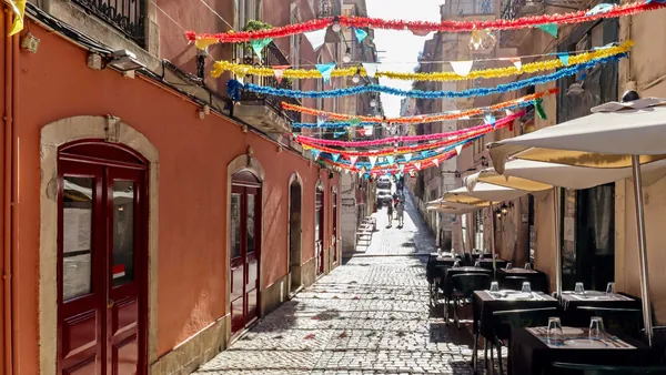 Calle decorada en la Mouraria de Lisboa con guirnaldas y terrazas