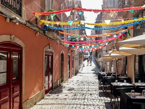 Calle decorada en la Mouraria de Lisboa con guirnaldas y terrazas