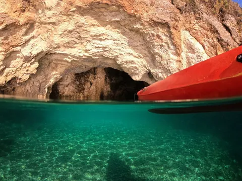 Kayak frente a cueva marina en Es Canutells, Menorca