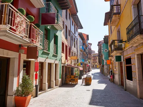 Calle peatonal de fachadas coloridas y balcones en el centro de Llanes, Asturias