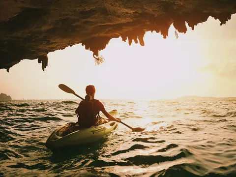 Mujer en kayak al atardecer en Es Grau, Menorca
