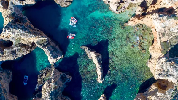 Vista picada de barcos en  las cuevas de Ponta da Piedade