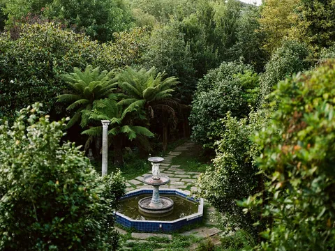 Fuente histórica entre la vegetación del jardín de Fonte Baxa, Luarca, Asturias
