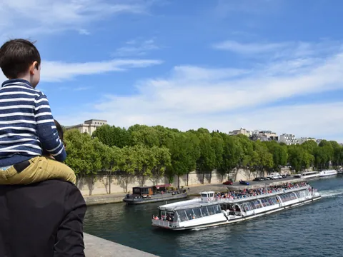 Familia observando un bateau mouche, uno de los barcos más famosos de París que navegan el río Sena.
