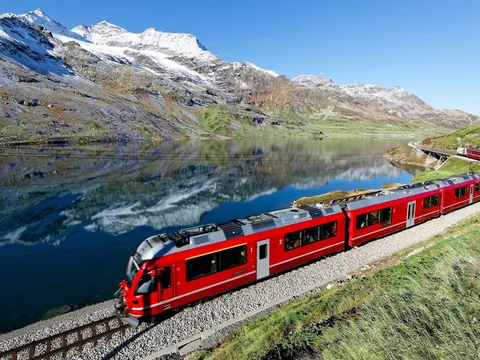 Bernina Express recorriendo los Alpes Suizos junto al lago en la ruta alpina