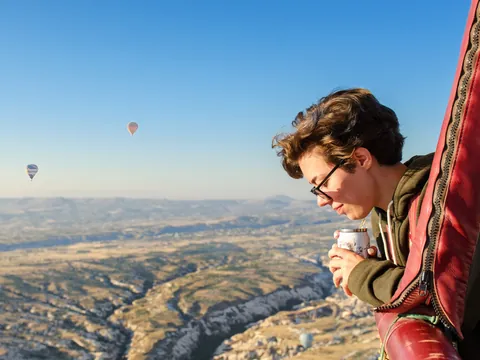 Persona disfrutando vuelo en globo sobre Capadocia al amanecer, Turquía