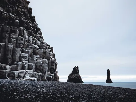Formaciones de basalto en la playa negra de Reynisfjara, Islandia, frente a los pilares marinos Reynisdrangar.