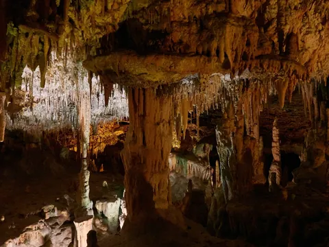 Iluminación colorida sobre estalagmitas y estalactitas en Cuevas dels Hams, Mallorca
