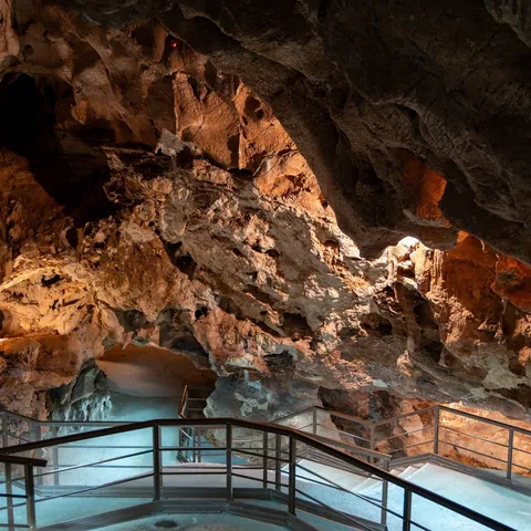 Pasarela y formaciones rocosas iluminadas en la Cueva del Tesoro, Málaga.