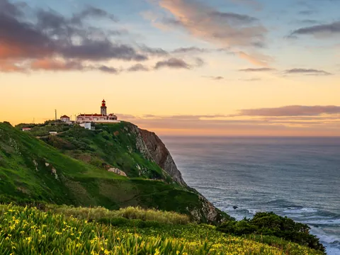 Atardecer en el Cabo da Roca con faro sobre acantilados, Portugal