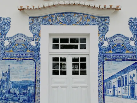 Fachada con azulejos azules decorativos de Aveiro alrededor de una puerta blanca.
