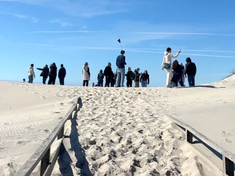 excursionistas en la playa de Costa Nova con buendía