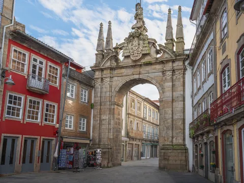 Arco da Porta Nova en Braga rodeado de casas tradicionales y fachadas coloridas.
