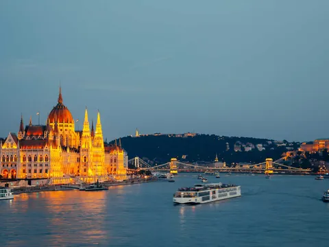 El Parlamento de Budapest iluminado de noche, visto desde un crucero en el Danubio.