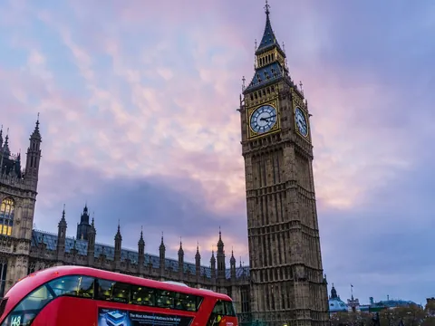 Big Ben y Palacio Westminster con autobús rojo londinense, iconos de Londres al atardecer
