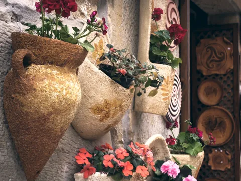 Macetas artesanales con flores en una fachada de Santillana del Mar.