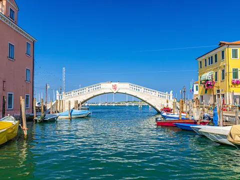 Puente blanco que forma parte del paisaje acuático de Chioggia.