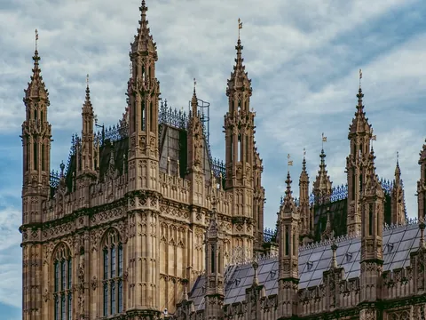 Fachada del Palacio de Westminster con detalles góticos, torres puntiagudas y decoración arquitectónica