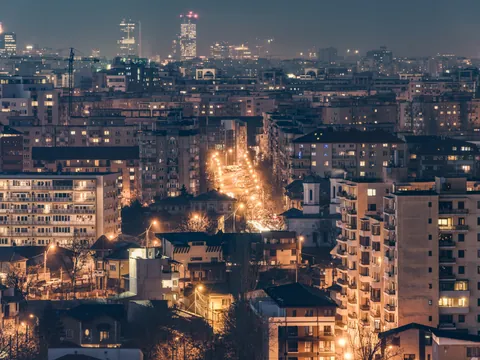 Vista aérea nocturna de Bucarest con las calles y edificios iluminados.