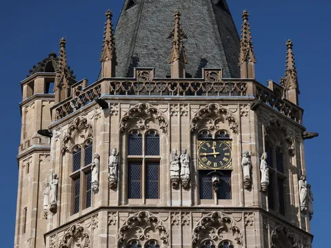 Detalle de la torre gótica del Ayuntamiento de Colonia con reloj y estatuas.