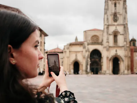 Turista fotografiando la Catedral de San Salvador de Oviedo con su móvil durante una visita al casco histórico de la ciudad.